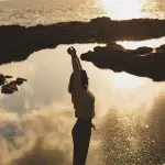 Figura en calma frente al mar al atardecer, símbolo de lo que queda cuando todo se apaga: la luz interior que sigue viva en el silencio.