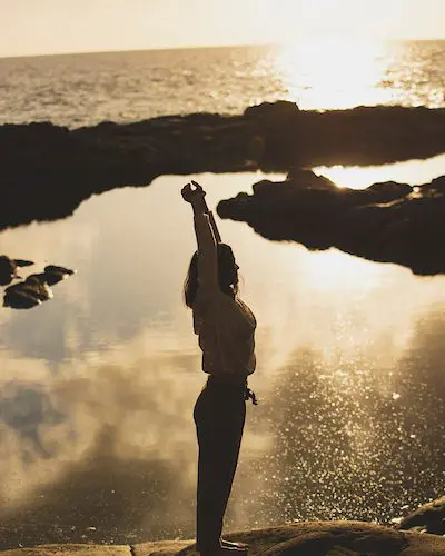 Figura en calma frente al mar al atardecer, símbolo de lo que queda cuando todo se apaga: la luz interior que sigue viva en el silencio.