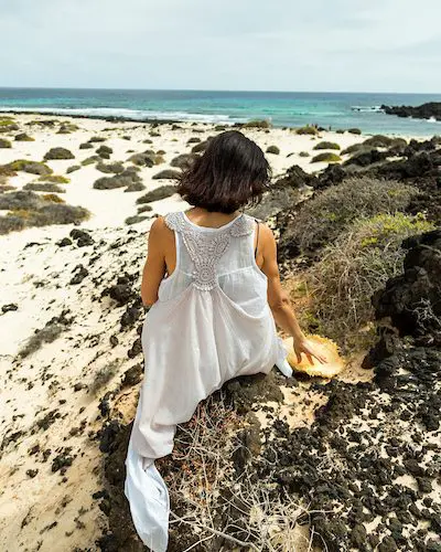 mujer de espaldas en Lanzarote — tensión en los hombros estrés emocional